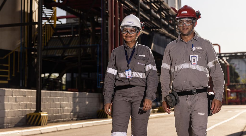 dois homens de uniforme e capacete caminhando e conversando